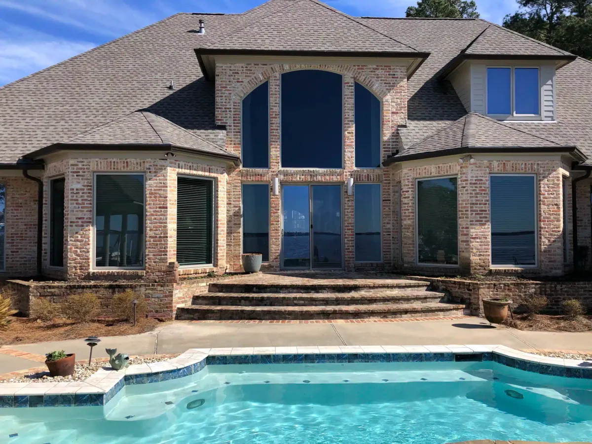Brick home with the new tall arched window over the pool