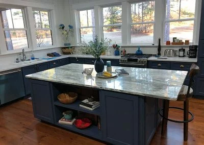 Kitchen with a row of new white windows above the counters looking out to the yard